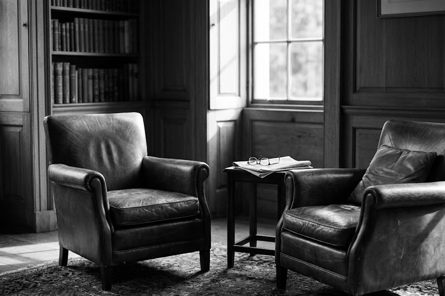 Two empty facing armchairs in a quiet study after a session has ended — what outlives the coach